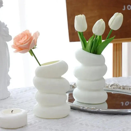 White ceramic spiral white vase with stacked rounded segments holding white tulips for home decor by DecorBites