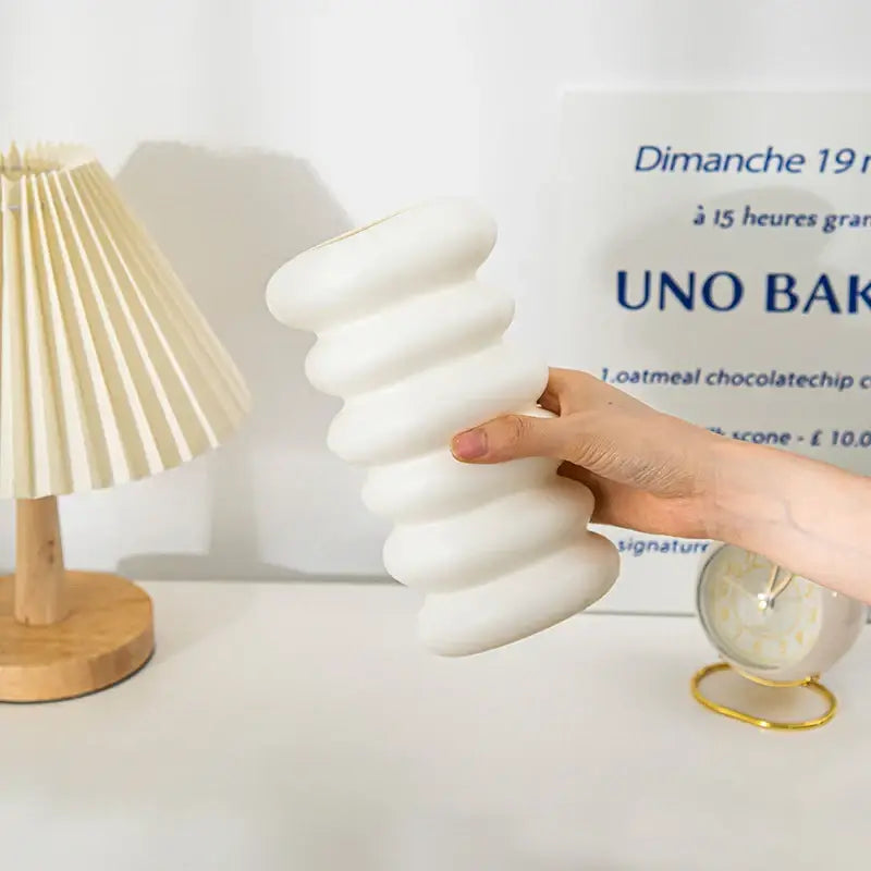 Decorbites spiral white vase is a white ceramic vase with a distinctive wavy segmented design for home decoration