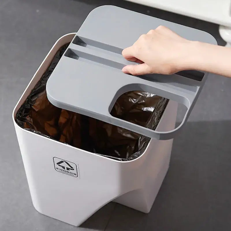 Gray plastic decorbites stackable trash can with matching lid featuring handles and cutout for kitchen recycling use