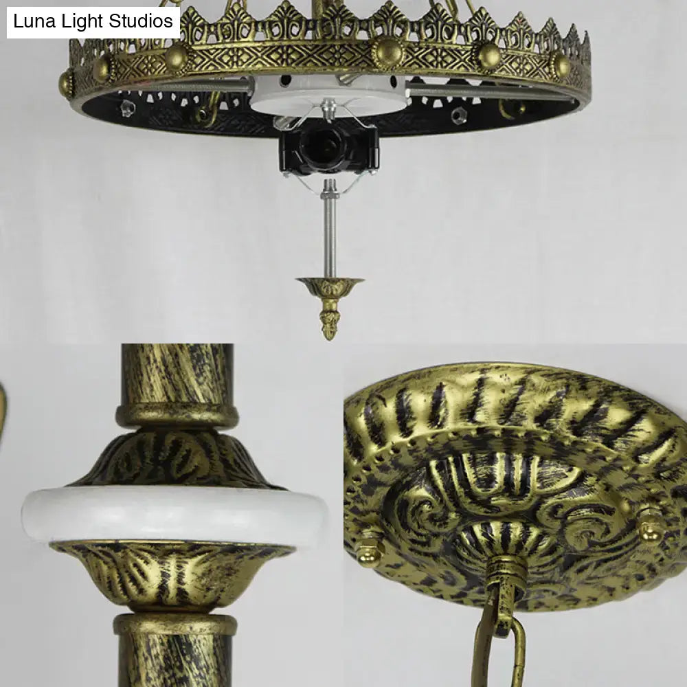 Antique brass ornate ceiling chandelier with intricate filigree and white ceramic ring for indoor kitchen lighting