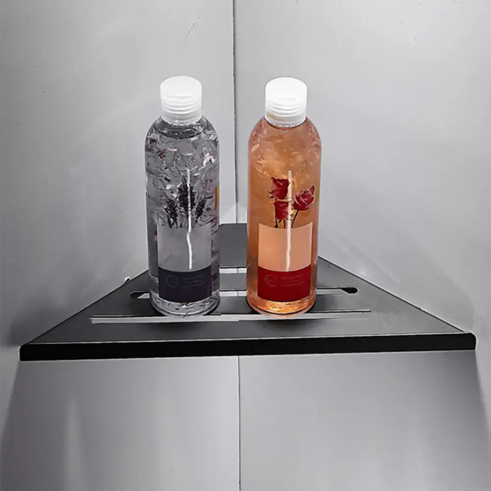 Two transparent plastic bottles with botanical liquids displayed on a decorbites stainless steel corner shower shelf organizer