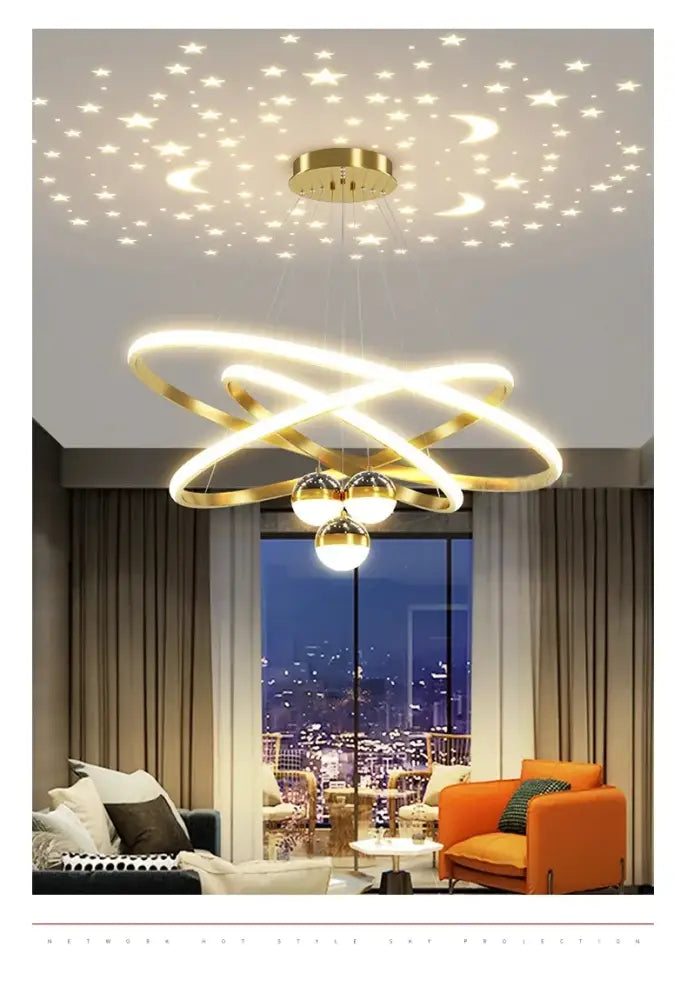 Gold-toned DecorBites™ starry sky led chandelier with intertwined rings and three bulbs casting warm glow in living room