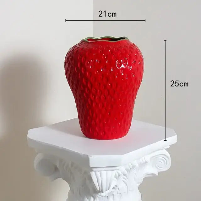 Vibrant red ceramic flower vase shaped like a cartoon strawberry with textured surface and green rim for home décor