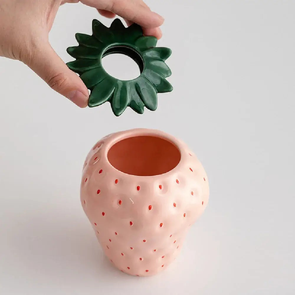 Pink ceramic strawberry shaped planter pot with green leafy lid by DecorBites™ for decorative use