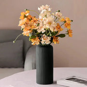 Decorbites™ striped ceramic-like plastic vase in black holding orange and cream artificial flowers bouquet