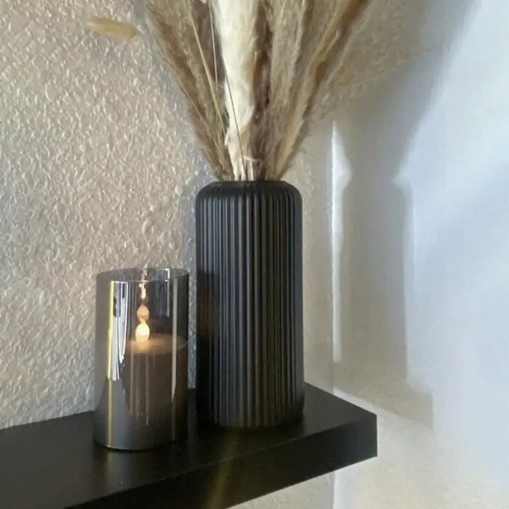 Black ribbed striped ceramic-like plastic vase from decorbites holding dried pampas grass for floral decor