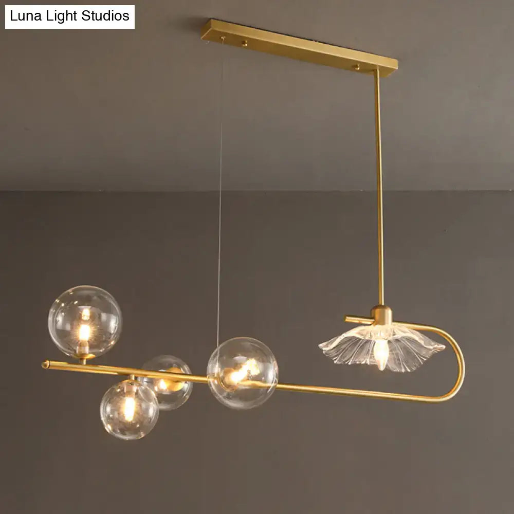 Gold-toned postmodern suspension lamp with lotus leaf design featuring clear glass globe bulbs and frosted glass shade