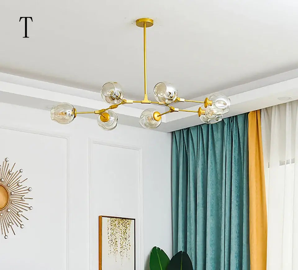 Gold-toned modern stylish nordic chandelier with clear glass globe bulbs for dining living room by DecorBites