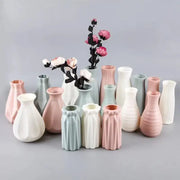 A collection of pastel-colored ceramic vases with geometric designs holding dried flowers for stylish home decor