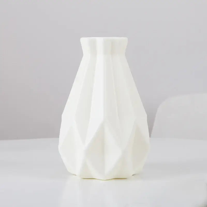 A sleek white ceramic flower vase with modern geometric facets and flared neck from decorbites plastic flower vase collection