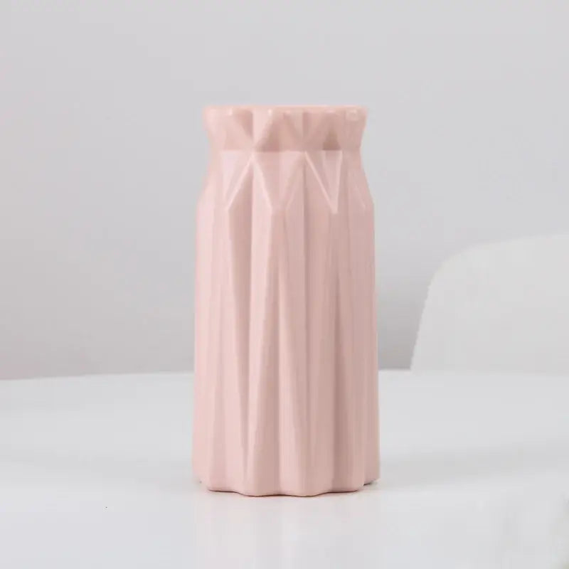 A soft pink plastic flower vase by DecorBites with a geometric faceted design for stylish home decor