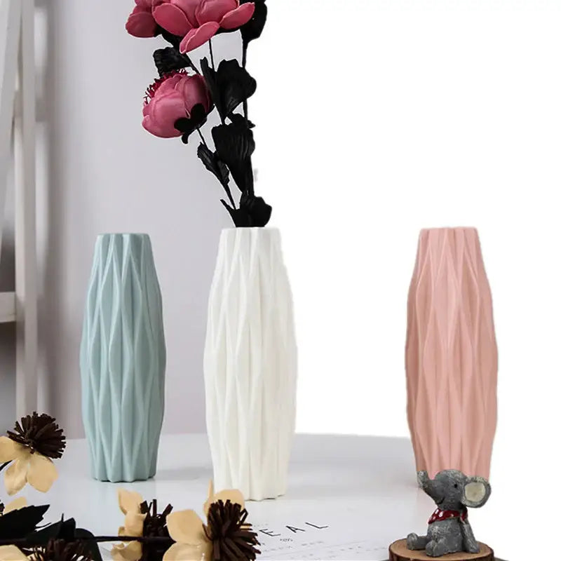 Three slender geometric decorbites™ plastic flower vases in mint green white and blush pink with dried flowers