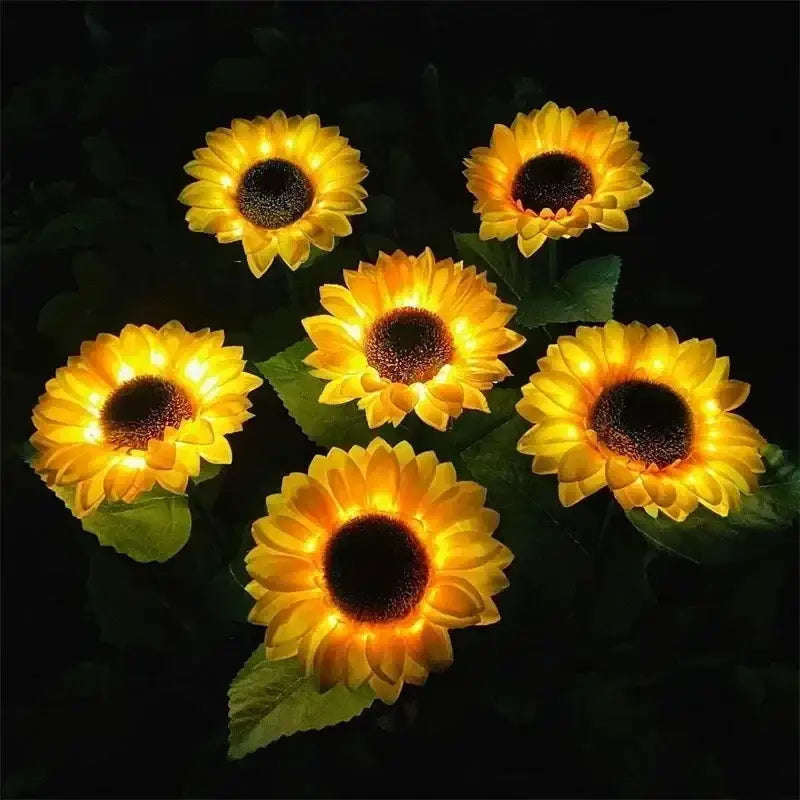 Six glowing yellow sunflower solar garden lights with dark centers and green leaves for solar lawn outdoor decor