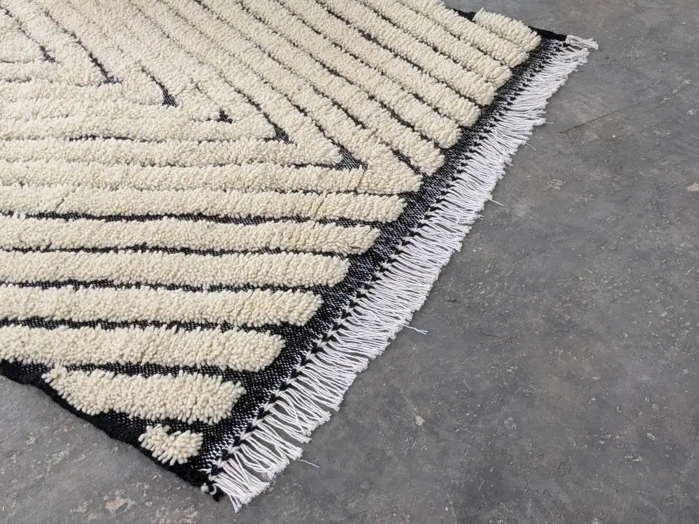 Black and cream beni ouarain tapis with geometric plush stripes and white fringe by decorbites 245 x 146 cm