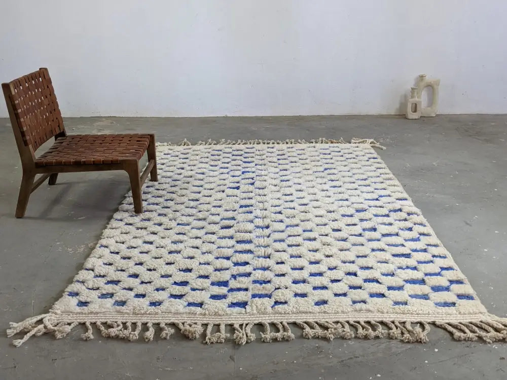 Cream-colored beni ouarain tapis beni ouarain rug with blue and white geometric woven squares and fringed edges