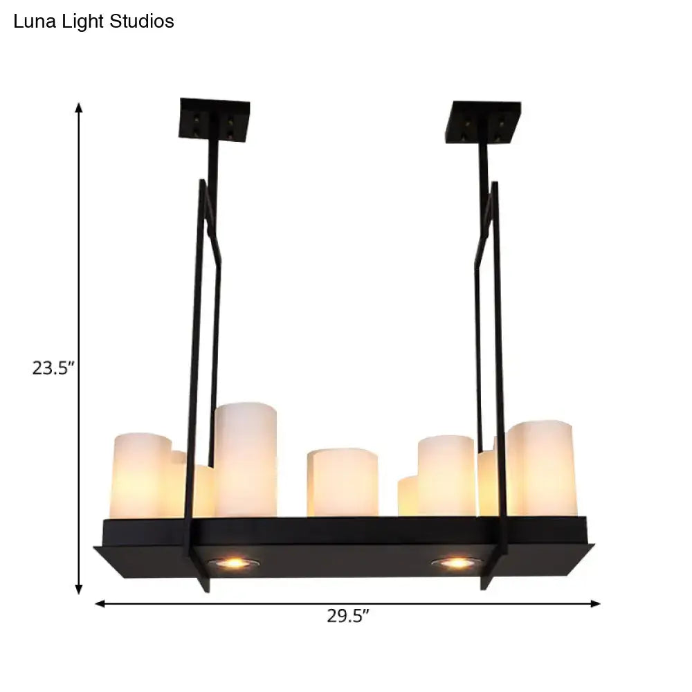 Black metal island pendant light with six frosted glass candle-style bulbs and two recessed lights in traditional barrel frosted design