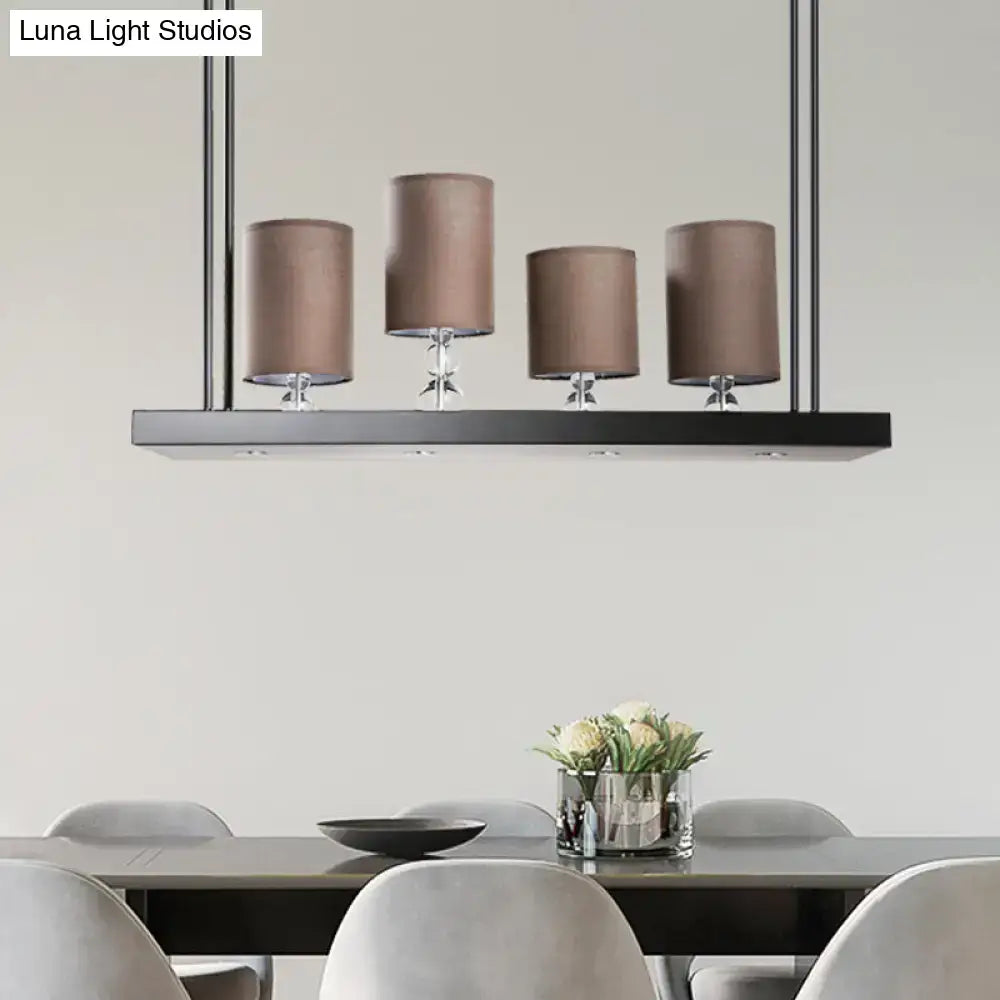 Modern decorbites island light fixture with four taupe fabric shades and black metal frame for dining room use