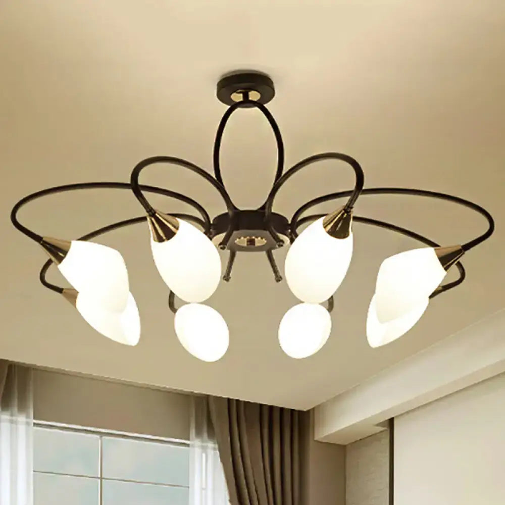 Black wrought iron chandelier with five frosted white glass shades and gold-toned accents for traditional oval white glass style lighting