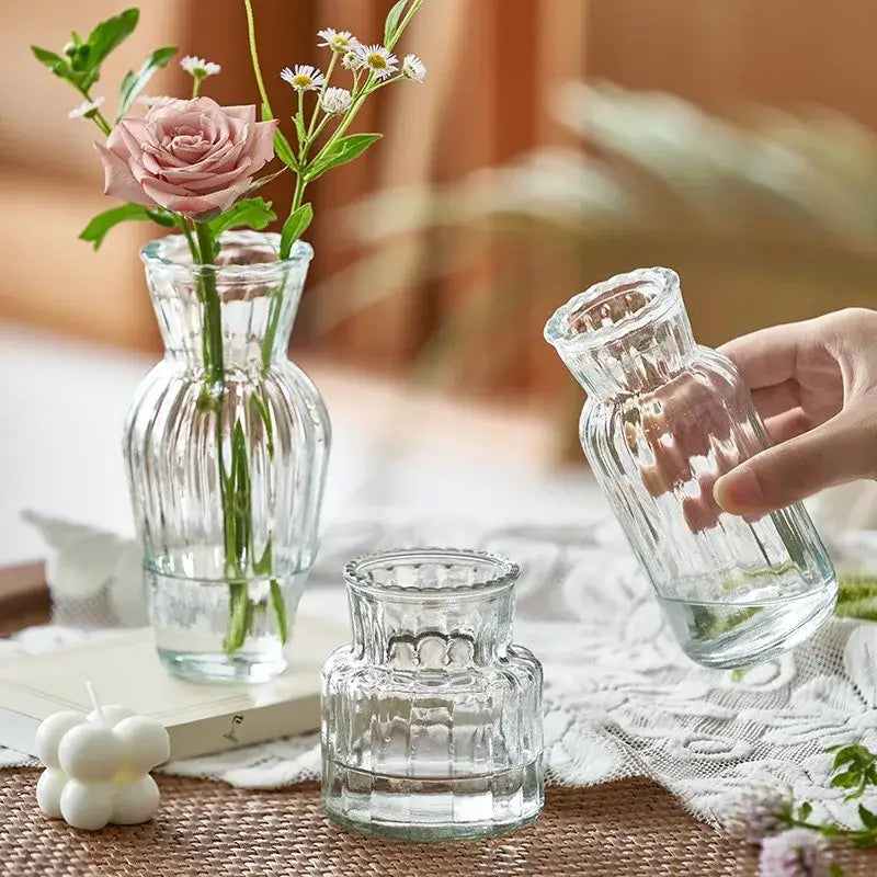 Decorbites™ transparent nordic vase in clear glass with ribbed texture holding a pink rose and white daisies