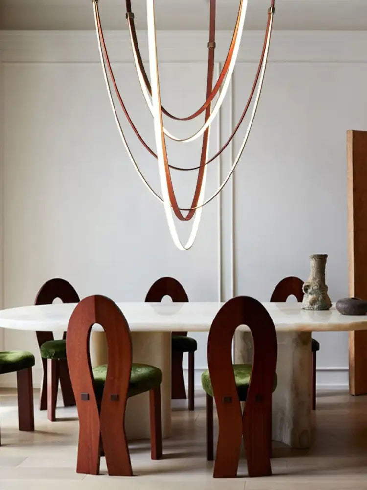 A DecorBites™ trendy flexible leather belt LED chandelier with layered curved brown and cream flexible leather straps