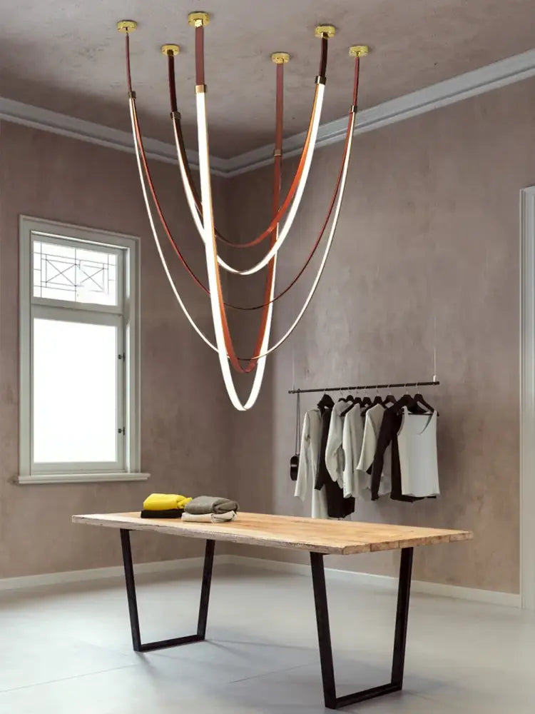 A modern DecorBites™ LED chandelier featuring flexible leather belt straps with curved illuminated strips in brown and white
