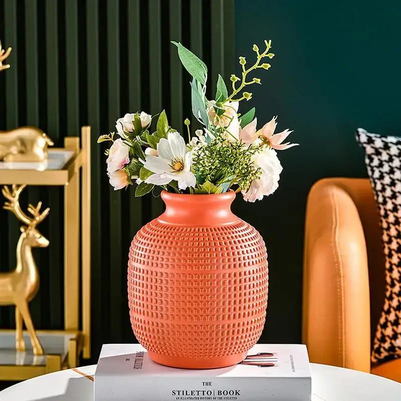 A coral-colored ceramic decorbites unbreakable modern floral vase with textured grid pattern holds white and pink flowers for home decor