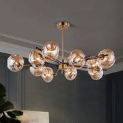 Modern brass-finished flush mount chandelier with amber-tinted glass globes for elegant living room lighting