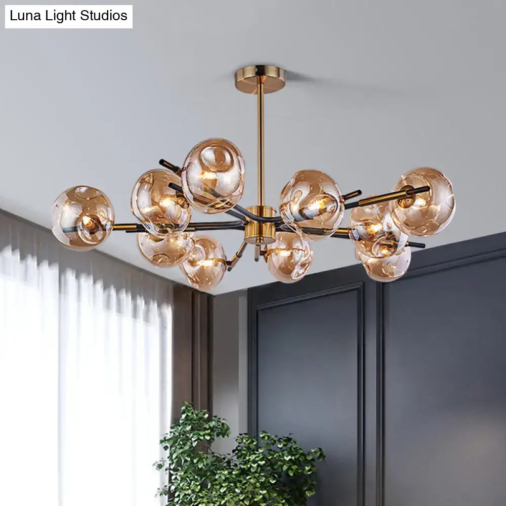 Modern brass-finished flush mount chandelier with amber-tinted glass globe shades for elegant living room lighting