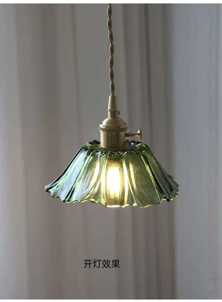 A delicate green flower glass pendant light with fluted design and brass hardware for vintage home decor by decorbites