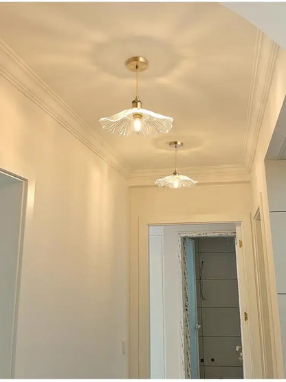 Two elegant brass-finished pendant lights with translucent flower glass shades for stylish home decor by DecorBites™