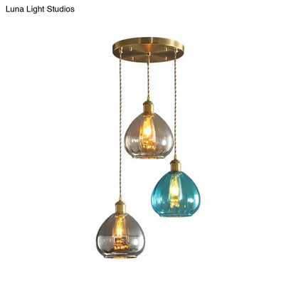 Three pendant glass onion multi ceiling lights with teal and clear teardrop shades and brass chains by decorbites