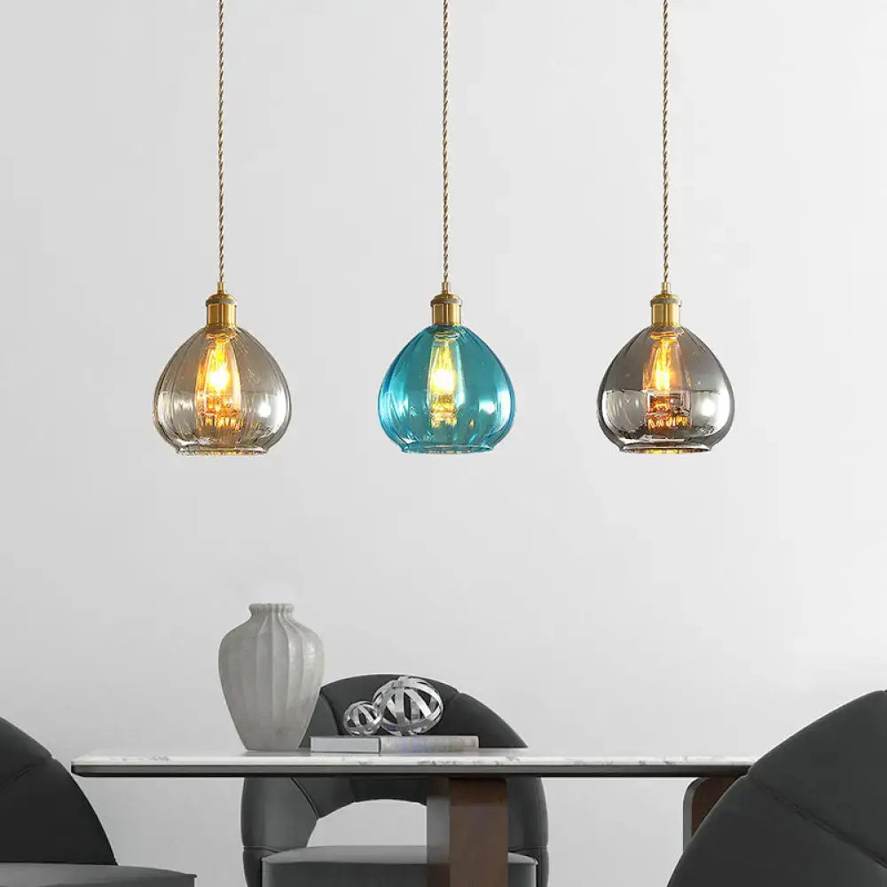 Three glass onion multi pendant lights with brass fixtures teal smoky gray and clear glass shades in multi ceiling light design