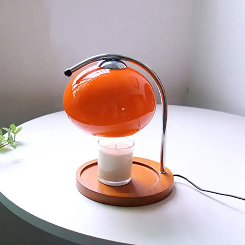 Vibrant orange spherical vintage glass table lamp with chrome stand and wooden base designed to hover above a candle