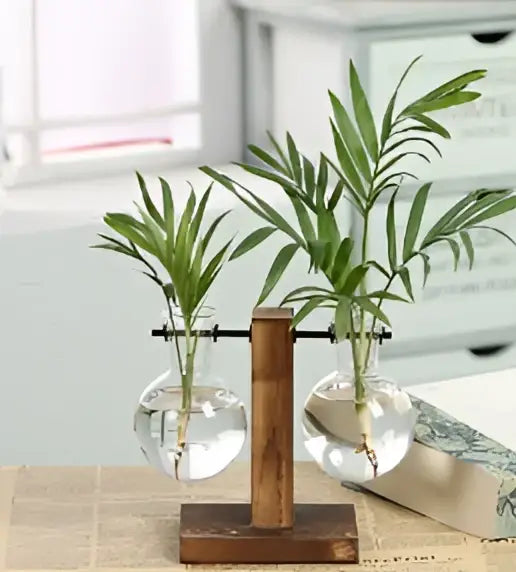 A clear glass vase with two green plants in round vessels suspended from a wooden frame glass stand decorbites vintage heart-shaped wooden frame glass vase