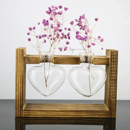 DecorBites™ vintage heart-shaped glass vase with wooden frame holding delicate purple dried flowers