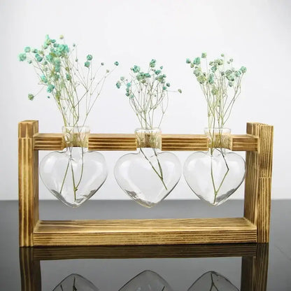 DecorBites™ vintage heart-shaped glass vase set with delicate baby’s breath flowers on a wooden frame glass stand