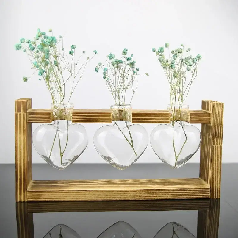 DecorBites™ vintage heart-shaped glass vase set with delicate baby’s breath flowers on a wooden frame glass stand