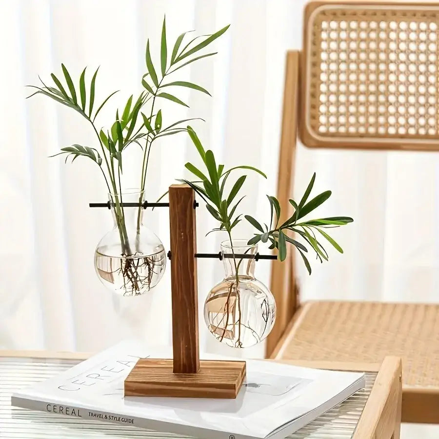 Wooden stand holding two bulb clear glass vases with visible roots and green palm-like plants for low style decor
