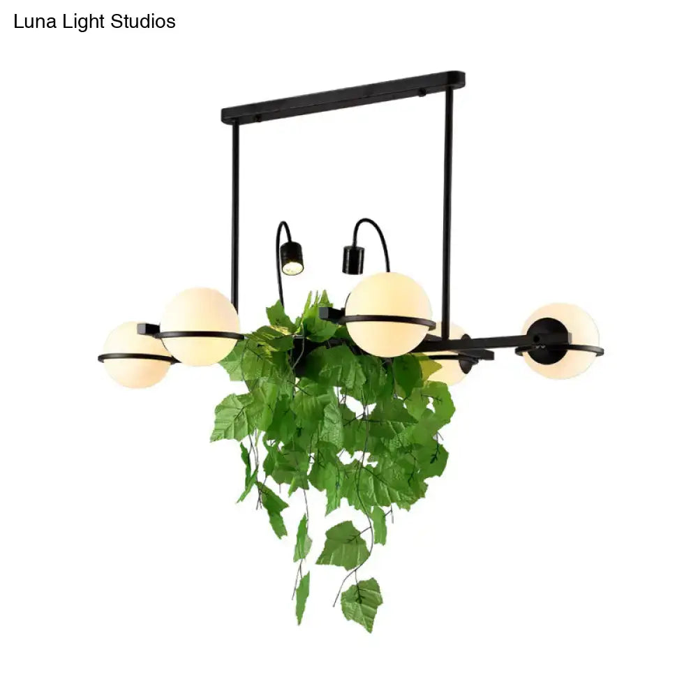 DecorBites™ vintage black metal island lighting fixture with spherical frosted glass shades and hanging green vine