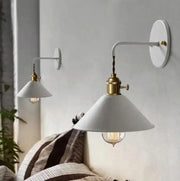 White conical shade vintage plated wall lamp with brass accents and visible filament bulb by decorbites