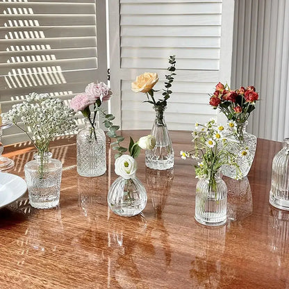Clear glass vintage relief vases with intricate etched patterns holding delicate flowers for hydroponic plants
