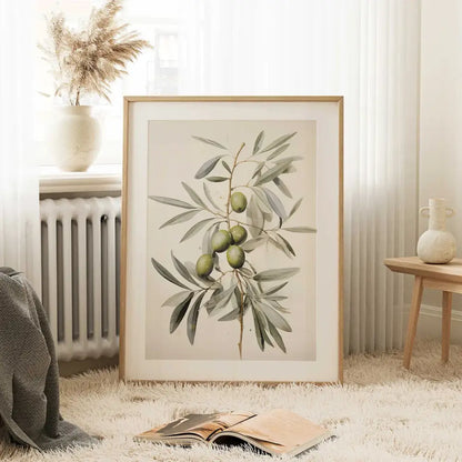 A framed vintage watercolor olive branch print with green olives and detailed leaves in a light wood frame by DecorBites