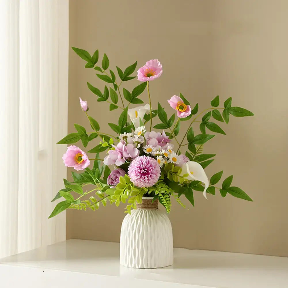 A white ripple plastic vase by decorbites with ribbed texture and rope band holding pink peonies and green foliage