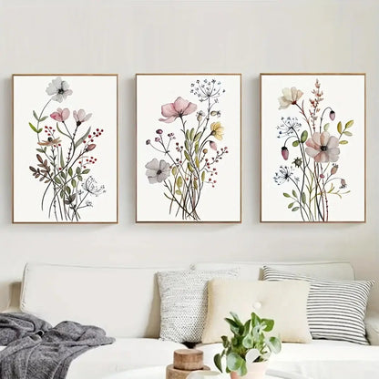 Three framed watercolor flower posters with delicate pink and white blooms on cream botanical canvas art by decorbites