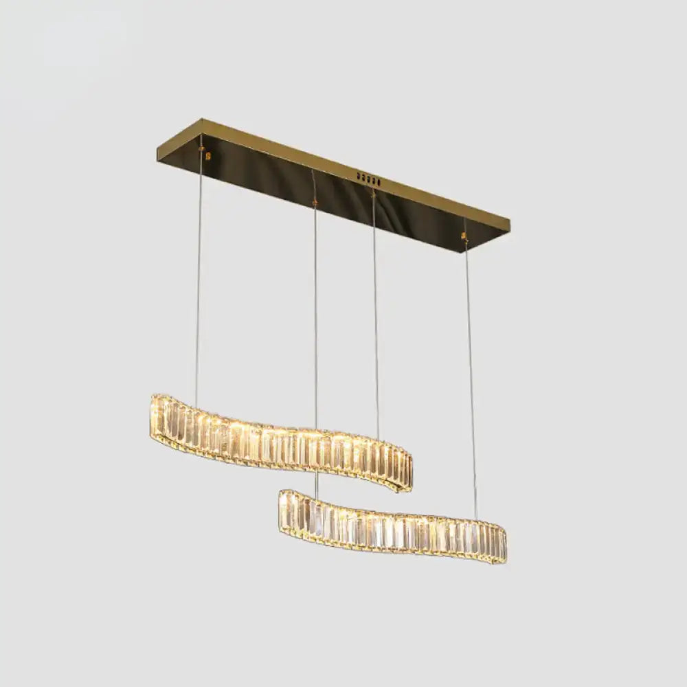 Modern gold-toned rectangular pendant light with two curved prismatic crystal tiers in brass finish for restaurants