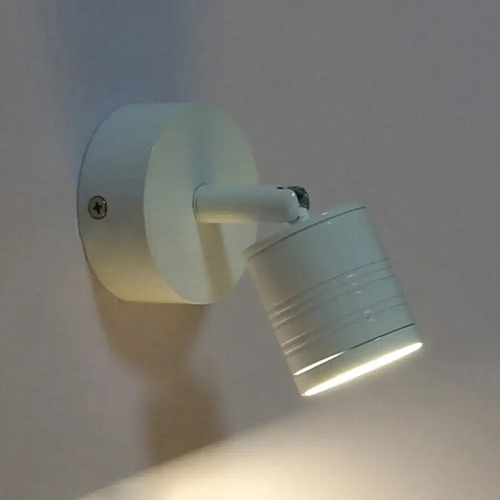 Modern ribbed white wall sconce lamp with cylindrical adjustable spotlight and warm white light for bedroom use