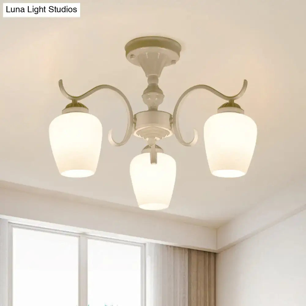 Cream-colored decorbites chandelier with three curved arms and frosted opaline glass cone shades in countryside style