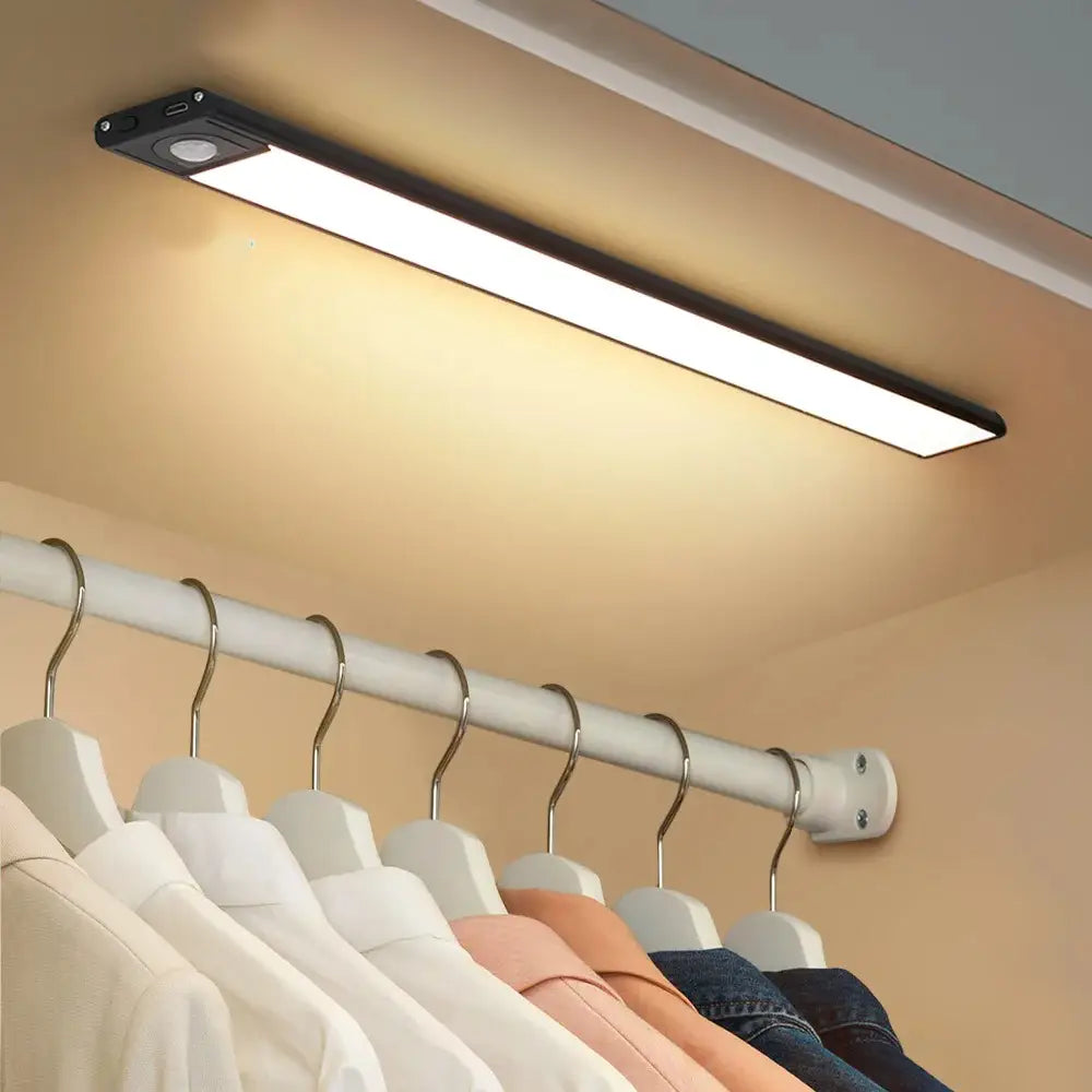 Decorbites™ wireless black led strip cabinet lighting mounted above clothing hangers as a sleek lighting solution