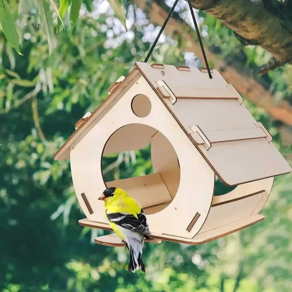 A light-colored wooden bird feeder with circular entrance and hinged roof showcasing natural wood grain for outdoor use
