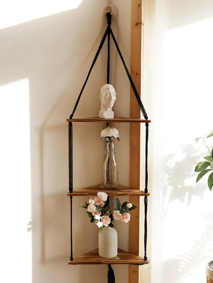 Black macrame cord suspends three wooden triangular shelves in a boho wooden corner shelf by DecorBites wooden corner shelf